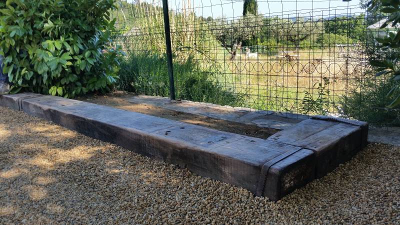 Terrain de pétanque avec traverses de chemin de fer en chêne traitées autoclave